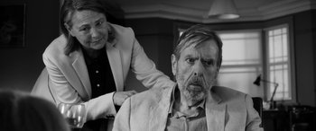 Movie still from “The Party” (2017), directed by Sally Potter – An older man and a younger woman in black and white; Medium shot, Over the shoulder angle