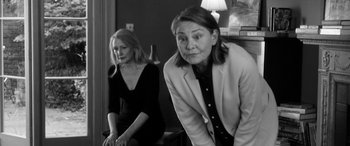 Movie still from “The Party” (2017), directed by Sally Potter – Two women sitting in a living room next to each other; Medium shot, Over the shoulder angle