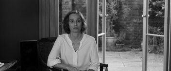 Movie still from “The Party” (2017), directed by Sally Potter – Black and white photograph of a woman sitting in a chair; Medium shot, Over the shoulder angle