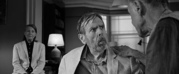 Movie still from “The Party” (2017), directed by Sally Potter – An older man with a goatee and a beard looking up; Close Up shot, Over the shoulder angle