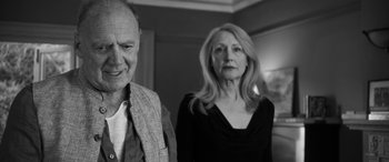 Movie still from “The Party” (2017), directed by Sally Potter – An older man standing next to an older woman; Close Up shot, Low angle
