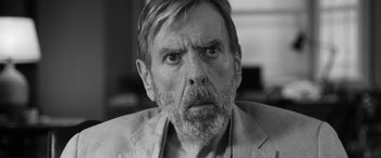 Movie still from “The Party” (2017), directed by Sally Potter – An older man with a beard and mustache looking at the camera; Close Up shot, Over the shoulder angle