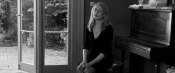 Movie still from “The Party” (2017), directed by Sally Potter – A black and white photo of a woman sitting on a bench; Medium shot, Low angle