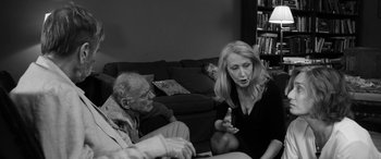 Movie still from “The Party” (2017), directed by Sally Potter – An older man and a younger woman sitting in a living room; Medium shot, Over the shoulder angle
