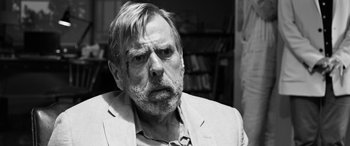 Movie still from “The Party” (2017), directed by Sally Potter – Black and white photograph of an older man in a suit; Close Up shot, Over the shoulder angle