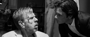 Movie still from “The Party” (2017), directed by Sally Potter – Two men are looking at each other in a black and white photo; Close Up shot, Over the shoulder angle