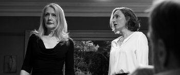 Movie still from “The Party” (2017), directed by Sally Potter – Two women standing next to each other in front of a building; Medium shot, Over the shoulder angle