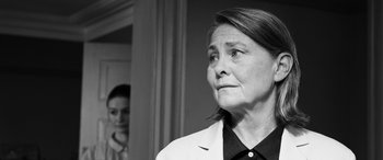 Movie still from “The Party” (2017), directed by Sally Potter – An older woman in a lab coat looking at the camera; Close Up shot, Over the shoulder angle