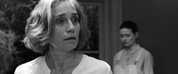 Movie still from “The Party” (2017), directed by Sally Potter – A woman in a white shirt is looking at the camera; Close Up shot, Over the shoulder angle
