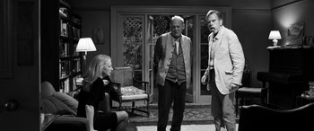 Movie still from “The Party” (2017), directed by Sally Potter – A group of people standing in front of a door; Wide shot, Over the shoulder angle