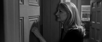 Movie still from “The Party” (2017), directed by Sally Potter – A black and white photo of a woman looking into a cabinet; Close Up shot, Over the shoulder angle