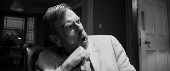 Movie still from “The Party” (2017), directed by Sally Potter – Black and white photograph of a man in a suit; Close Up shot, Over the shoulder angle