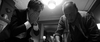 Movie still from “The Party” (2017), directed by Sally Potter – A man and an older man playing a game of chess; Close Up shot, Over the shoulder angle