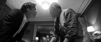 Movie still from “The Party” (2017), directed by Sally Potter – A man and a young boy talking to each other; Medium shot, Over the shoulder angle