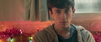 A young man is looking into the camera