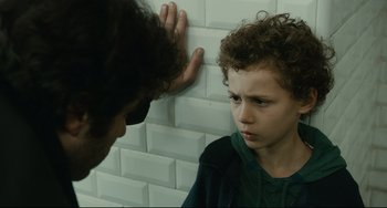 A young boy looking at another young man