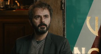 Movie still from “The Past” (2013), directed by Asghar Farhadi – A man with a beard is looking at the camera; Close Up shot, Over the shoulder angle