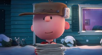 Movie still from “The Peanuts Movie” (2015), directed by Steve Martino – A charlie brown character is sitting on a stack of papers; Medium shot, Low angle