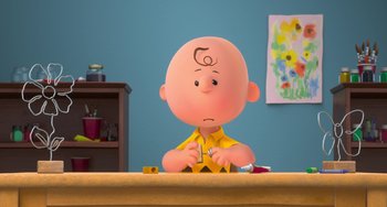 Movie still from “The Peanuts Movie” (2015), directed by Steve Martino – A charlie brown character sitting at a table; Medium shot, High angle
