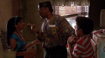 Movie still from “The People Under the Stairs” (1991), directed by Wes Craven – A group of people standing in a living room; Medium shot, Over the shoulder angle