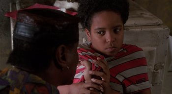 Movie still from “The People Under the Stairs” (1991), directed by Wes Craven – A young woman holding her hand up to her face; Close Up shot, Over the shoulder angle