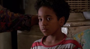 Movie still from “The People Under the Stairs” (1991), directed by Wes Craven – A young boy is sitting in front of a wall; Close Up shot, High angle