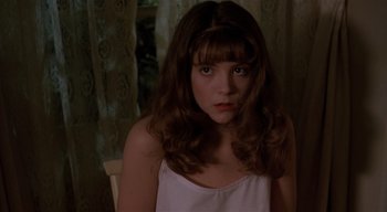 Movie still from “The People Under the Stairs” (1991), directed by Wes Craven – A young woman with long brown hair wearing a white top; Close Up shot, High angle