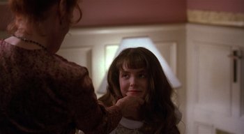 Movie still from “The People Under the Stairs” (1991), directed by Wes Craven – A woman putting a necklace on a young girl's face; Close Up shot, Over the shoulder angle