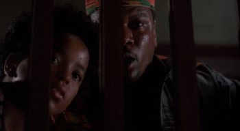 Movie still from “The People Under the Stairs” (1991), directed by Wes Craven – A man and a child are looking at the camera; Close Up shot, Low angle
