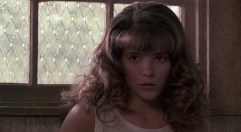 Movie still from “The People Under the Stairs” (1991), directed by Wes Craven – A young woman with long hair and bangs looking at the camera; Close Up shot, Low angle