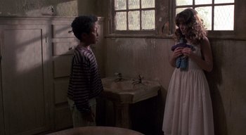 Movie still from “The People Under the Stairs” (1991), directed by Wes Craven – Two children are standing in a room in front of a sink; Medium shot, Over the shoulder angle