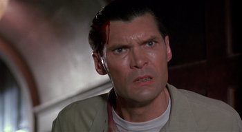 Movie still from “The People Under the Stairs” (1991), directed by Wes Craven – A man that has blood all over his face; Close Up shot, Low angle