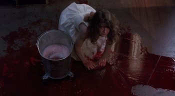 Movie still from “The People Under the Stairs” (1991), directed by Wes Craven – A woman in a white dress is kneeling on the floor; Medium shot, High angle