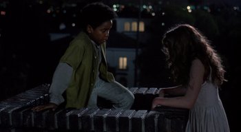 Movie still from “The People Under the Stairs” (1991), directed by Wes Craven – A boy and a girl are sitting on a bench; Medium shot, High angle