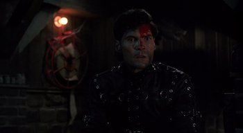Movie still from “The People Under the Stairs” (1991), directed by Wes Craven – A man in a black jacket with a red face paint; Close Up shot, Over the shoulder angle