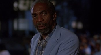 Movie still from “The People Under the Stairs” (1991), directed by Wes Craven – An older man wearing a blue jacket and a plaid shirt; Close Up shot, Low angle
