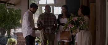 Movie still from “The Perfect Guy” (2015), directed by David M. Rosenthal – A group of people standing next to each other holding flowers; Medium shot, Over the shoulder angle