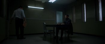 Movie still from “The Perfect Guy” (2015), directed by David M. Rosenthal – A man sitting at a table in a dark room; Wide shot, High angle