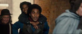 Movie still from “The Personal History of David Copperfield” (2019), directed by Armando Iannucci – A man and a woman smiling for the camera; Medium shot, Over the shoulder angle