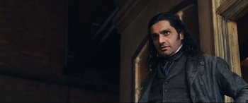 Movie still from “The Personal History of David Copperfield” (2019), directed by Armando Iannucci – A person with long black hair; Medium shot, Low angle