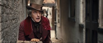 Movie still from “The Personal History of David Copperfield” (2019), directed by Armando Iannucci – A man wearing a top hat and holding a cane; Medium shot, Over the shoulder angle