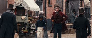 Movie still from “The Personal History of David Copperfield” (2019), directed by Armando Iannucci – An older man and a young boy are walking down the street; Wide shot, Over the shoulder angle