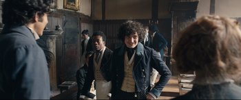 Movie still from “The Personal History of David Copperfield” (2019), directed by Armando Iannucci – Two young men are posing for a picture; Medium shot, Over the shoulder angle