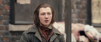 Movie still from “The Personal History of David Copperfield” (2019), directed by Armando Iannucci – A man with long brown hair wearing a jacket; Close Up shot, Low angle