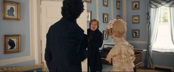 Movie still from “The Personal History of David Copperfield” (2019), directed by Armando Iannucci – A woman in a black coat talking to two other people; Medium shot, Over the shoulder angle