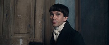 Movie still from “The Personal History of David Copperfield” (2019), directed by Armando Iannucci – A man in a black suit and a white shirt; Close Up shot, Over the shoulder angle