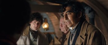 Movie still from “The Personal History of David Copperfield” (2019), directed by Armando Iannucci – A group of men standing next to each other; Medium shot, Over the shoulder angle