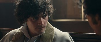 Movie still from “The Personal History of David Copperfield” (2019), directed by Armando Iannucci – A person wearing a jacket; Close Up shot, Over the shoulder angle