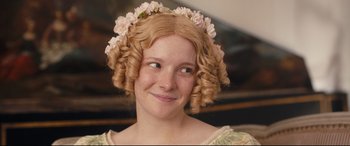 Movie still from “The Personal History of David Copperfield” (2019), directed by Armando Iannucci – A young woman with blonde hair wearing a flower crown; Close Up shot, Over the shoulder angle