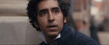 Movie still from “The Personal History of David Copperfield” (2019), directed by Armando Iannucci – A person wearing a suit and tie; Close Up shot, High angle